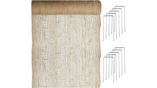 The image shows a steep, eroded hillside stabilized with erosion control blankets for effective slope management.