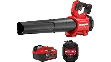 The image shows a person using a powerful battery-powered leaf blower to clear debris from a lawn.