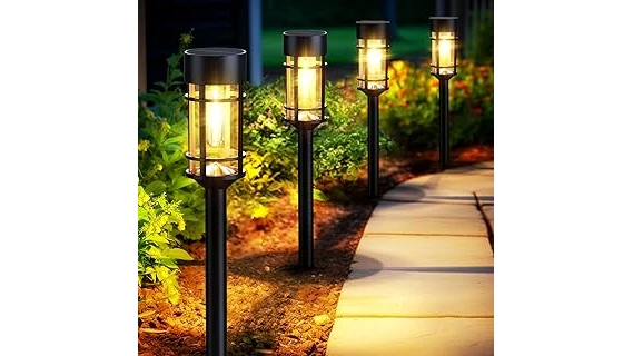 The image shows several elegant metal solar path lights illuminating a garden walkway at dusk.